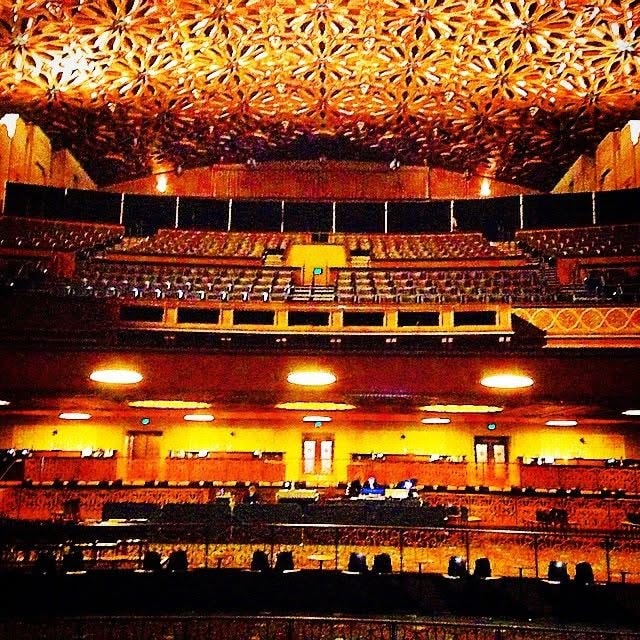 Ornate concert hall interior with tiered balconies and warm lighting