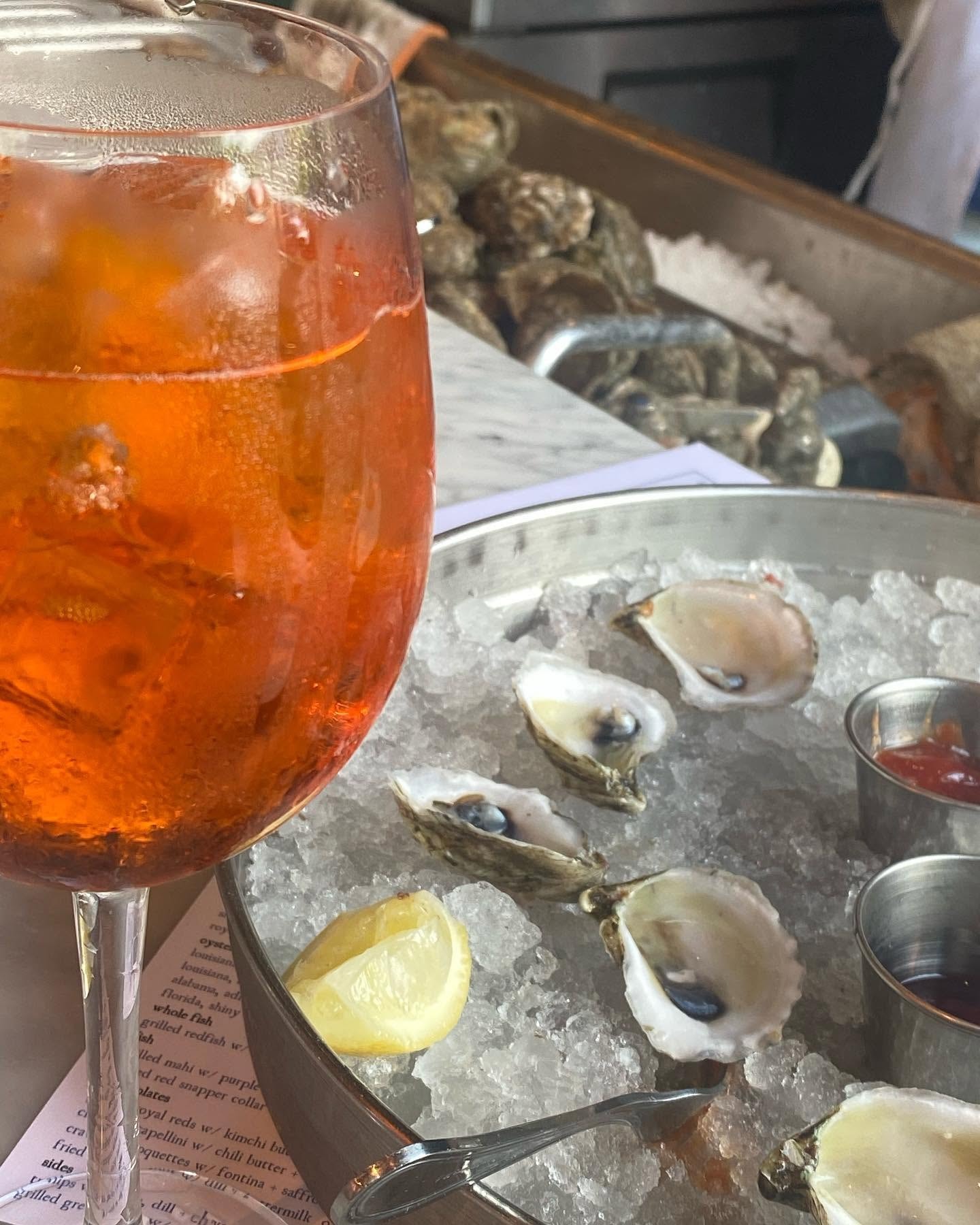 Aperol spritz and fresh oysters on a sun-drenched table