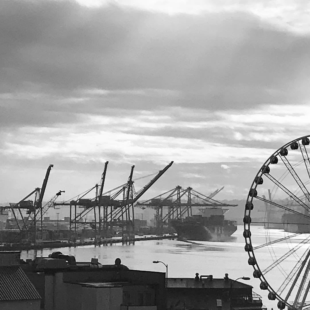 Seattle waterfront with shipping cranes and Ferris wheel